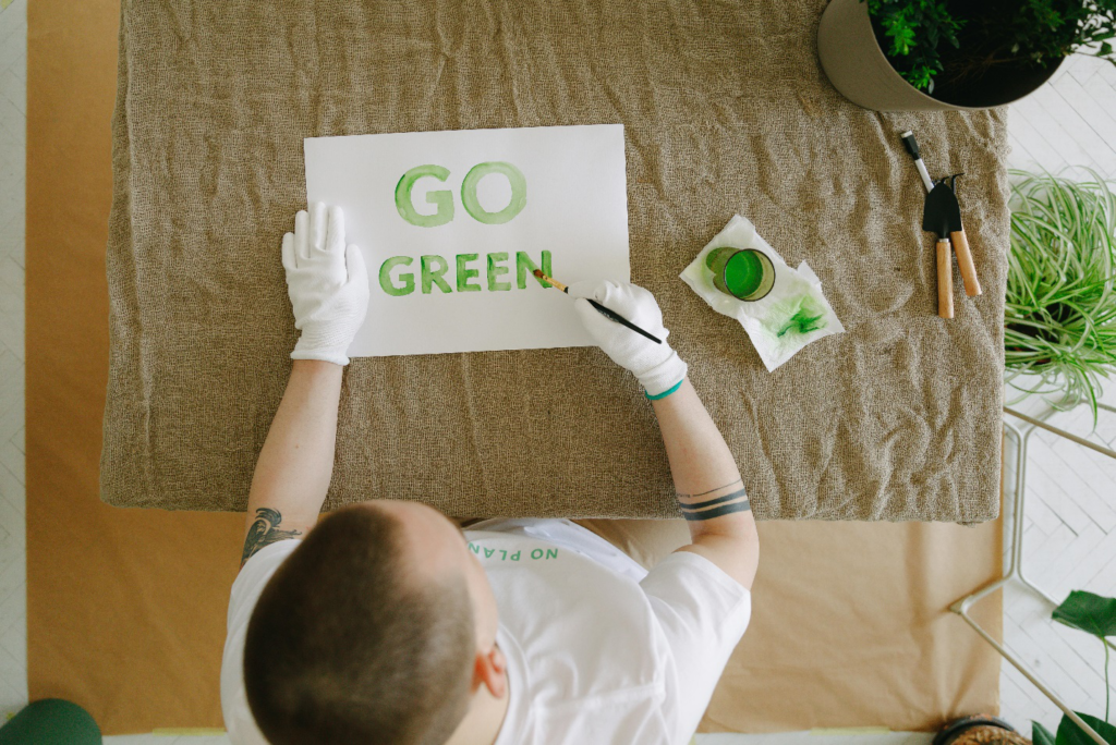 Person Painting a “Go Green” Sign